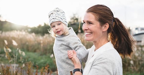 Mor og sønn leker ute i gresset, til illustrasjon for familieøkonomi