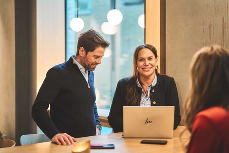 Ansatte i BN Bank sammen rund en pc, illustrasjon til boligsparing