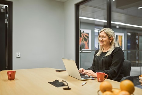 Bedriftsrådgiver Ailin sitter i BN Bank sitt lokale, til illustrasjon for bli bedriftskunde