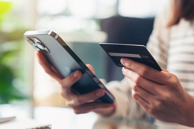 Dame holde kredittkort og mobil i hånden