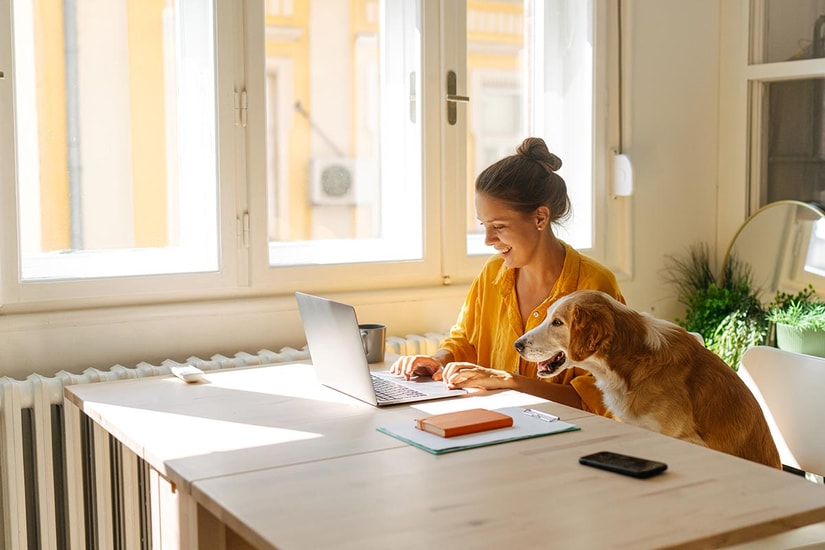 Dame og hund sitter ved spisebordet, til illustrasjon for hva er innskuddsrente