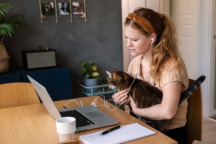 Jente ser på pc med katt i fanget, illustrasjon til hvordan spare til bolig