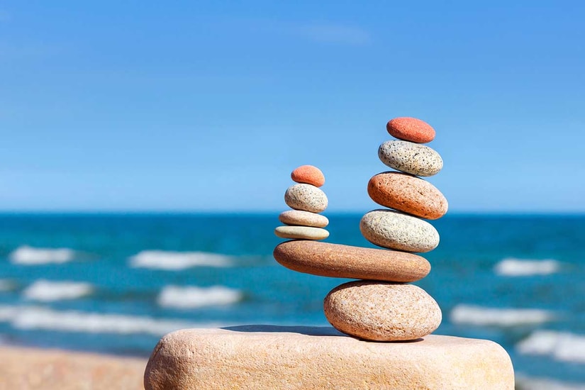 Steiner balanserer på hverandre fremfor havet, til illustrasjon for FNs bærekraftsmål