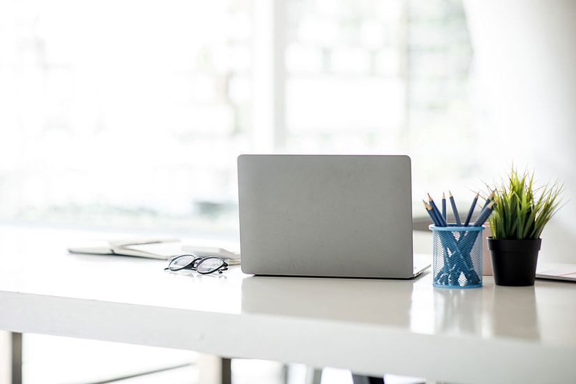 Bok, laptop, briller og blyanter på en skrivepult, til illustrasjon for problemer med innlogging