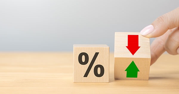 Kvinner holder en klosse med pil opp og pil ned og andre klosse med prosenttegn ved siden av, til illustrasjon for styringsrente