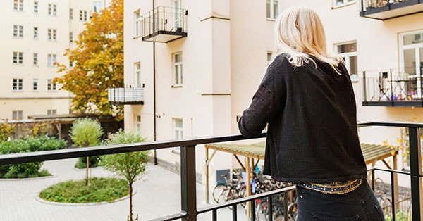 Jente på balkongen i boligblokk, til illustrasjon for hvor mye kan jeg låne