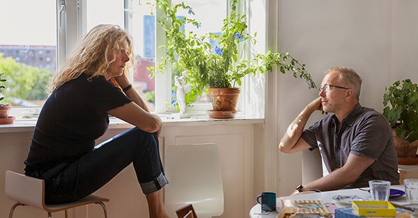 Par i samtale på kjøkkenet, til illustrasjon for samlivsbrudd og økonomi