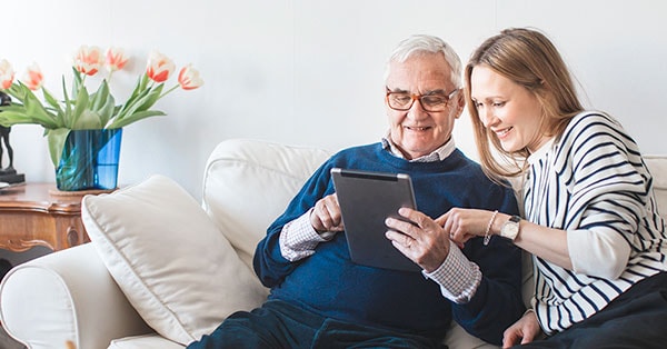 Dame hjelper eldre mannmed å skrive fremtidsfullmakt