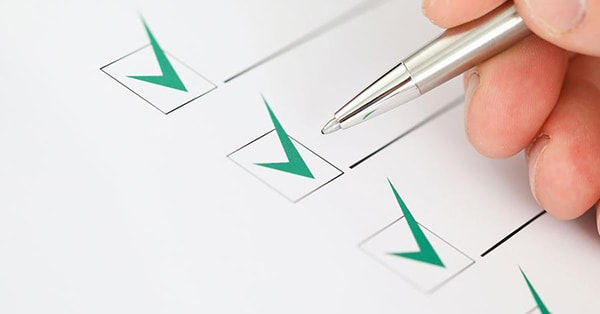 Mann med penn krysser ut i bokser